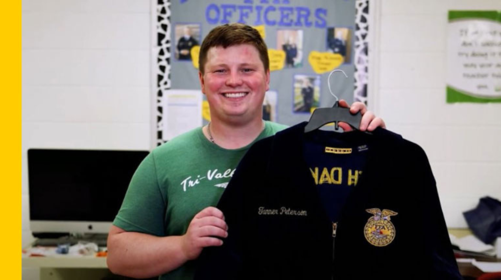 Tanner Peterson holds up the FFA jacket he earned when he was a student