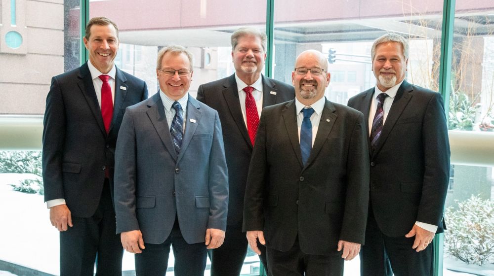Five men standing in suits.
