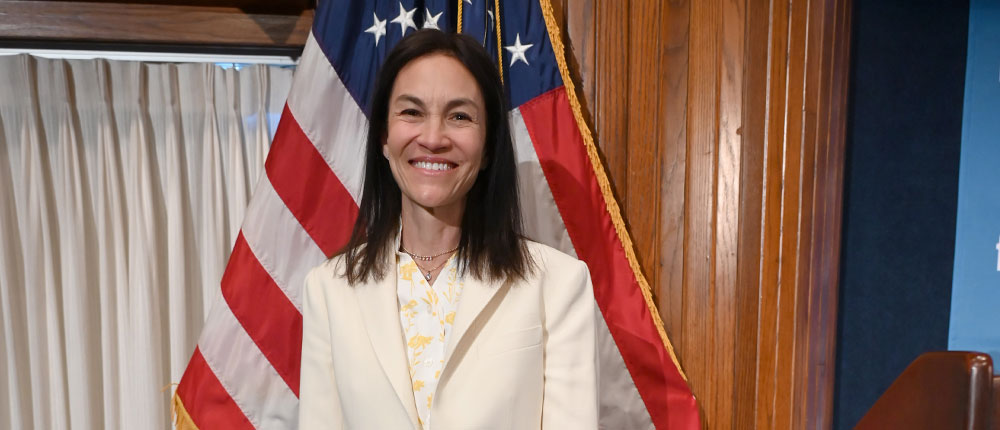 Sarah Bovim standing in front of American flag