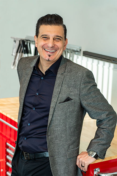 Ahmad Popal smiles while standing in a culinary workspace.
