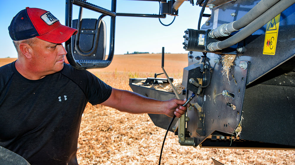 man greasing equipment in field
