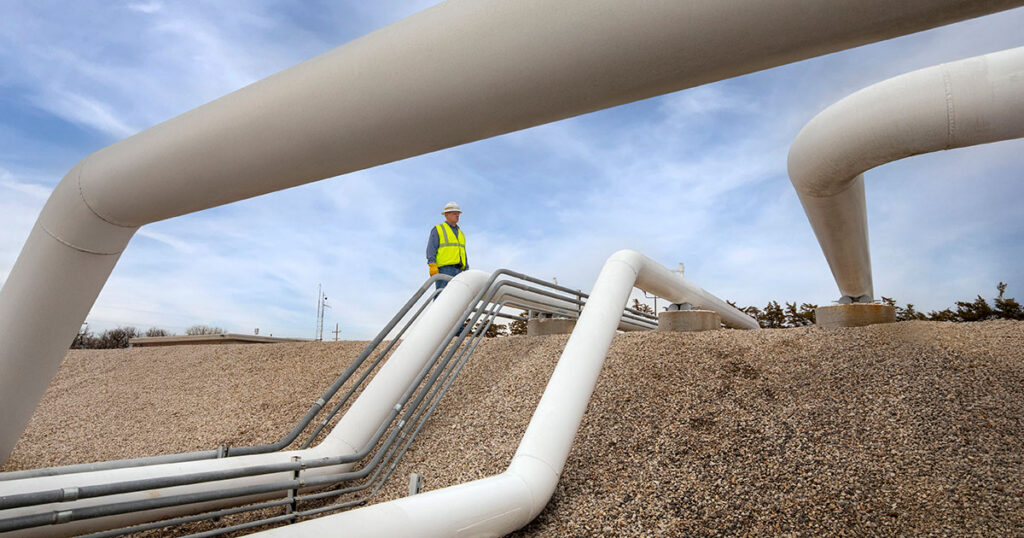 Man standing by pipes.