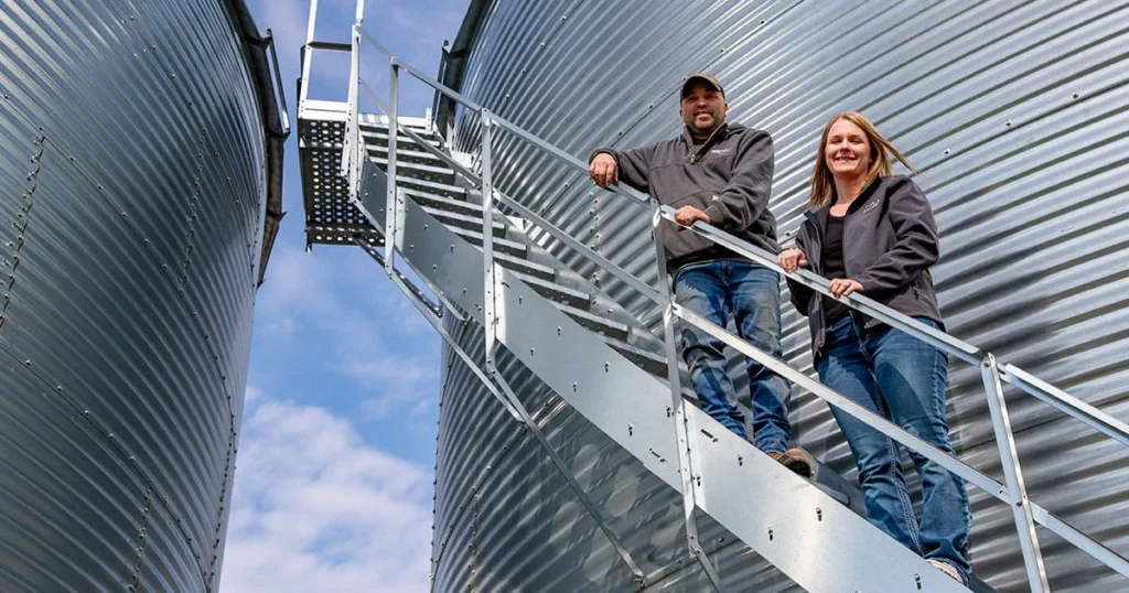 Man and woman on grain bin stairs