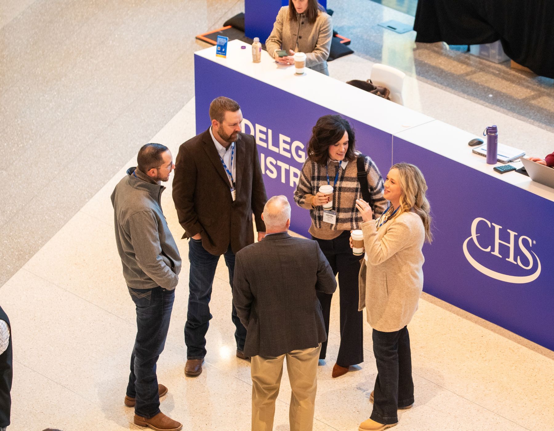 Group of people standing in a circle talking.